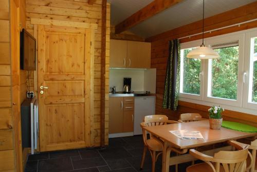 een keuken en eetkamer met een tafel en stoelen bij Camping "De Stuurmanskolk" in Welsum