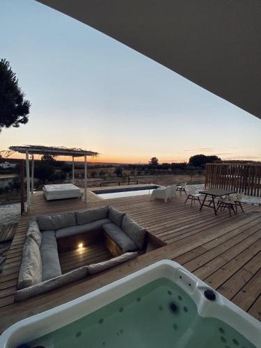 a hot tub sitting on a wooden deck with a deck at Casa Branca - Monte dos Rolas in Alcácer do Sal