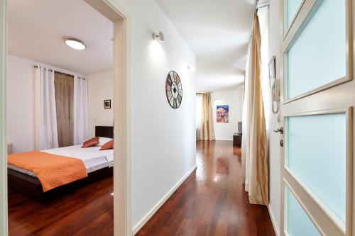 a bedroom with a bed and a clock on the wall at Apartments Gea Trogir in Trogir
