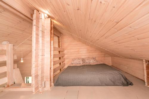 1 dormitorio con 1 cama en una habitación de madera en Дом LBerry Мята у Ладоги en Sortavala
