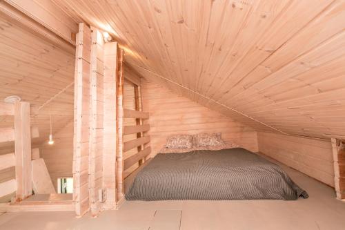 a bedroom with a bed in a wooden room at Дом LBerry Мята у Ладоги in Sortavala