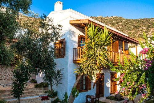 ein weißes Haus mit einem Balkon und Bäumen in der Unterkunft Courtyard in Kalkan