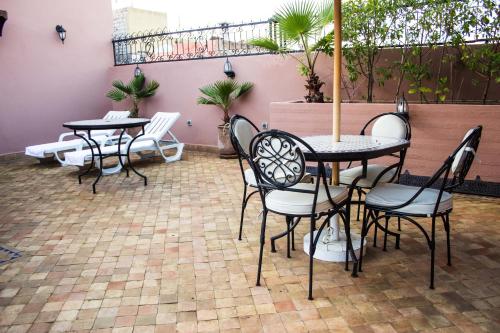 a patio with tables and chairs and a balcony at Riad Merzouga in Marrakech