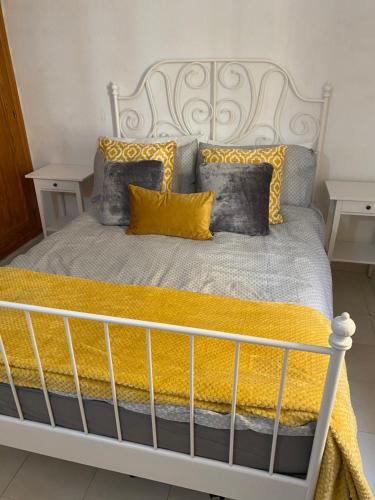 sypialnia z białym łóżkiem z żółtymi i szarymi poduszkami w obiekcie Caletaparaiso110 w mieście Costa de Antigua