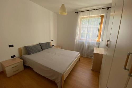 a small bedroom with a bed and a window at Mountain&Lake Apartment - CIPAT: 022104-AT-849776 in Levico Terme