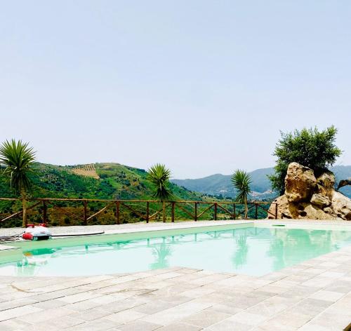 a swimming pool with a mountain in the background at Mama Lina in Patti