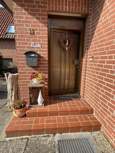 a cat is sitting in front of a door at Ferienwohnung Ram 1 in Hermannsburg