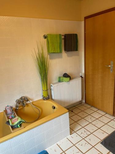 a bathroom with a yellow tub with a plant in it at Ferienwohnung Ram 1 in Hermannsburg