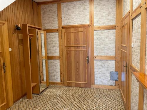a room with wooden doors and a brick wall at Ferienwohnung Ram 1 in Hermannsburg