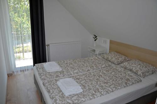 a bedroom with a large bed with two towels on it at Fanni Vendégház in Dombóvár