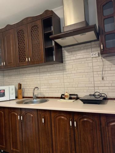 a kitchen with wooden cabinets and a sink at Котедж ''Олечка'' in Yaremche