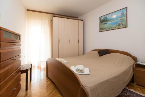 a bedroom with a bed with two towels on it at Apartmani Vera in Crikvenica