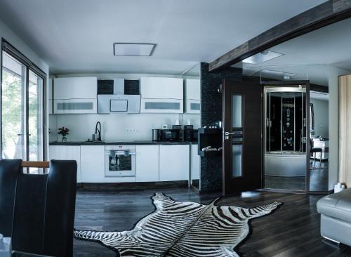 a kitchen with a zebra rug in the middle of a room at Golden Beach Apartment in Chlʼaba