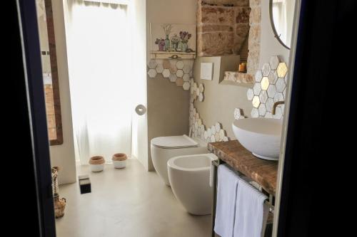 a bathroom with a sink and a toilet at Trulli Terra Magica in Putignano