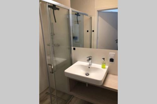 a bathroom with a sink and a shower at Rewal Apartament "PANORAMA" in Rewal