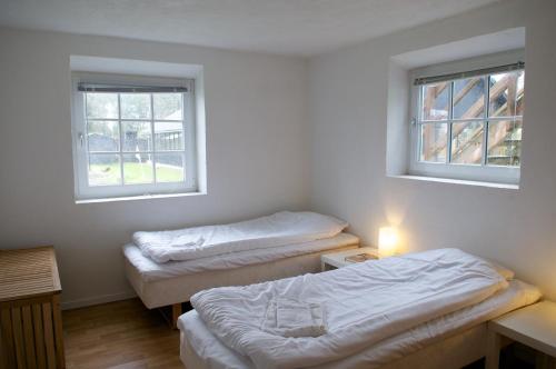 two beds in a room with two windows at Nymarksminde in Vodskov