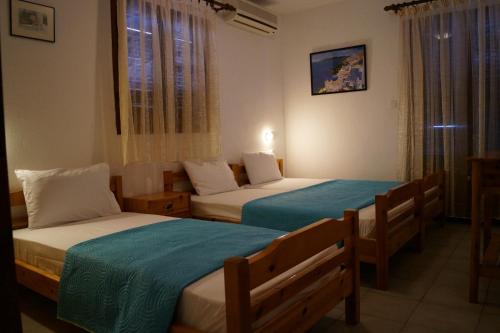 um quarto de hotel com duas camas e uma janela em Hotel Castelli em Kallithea Halkidikis