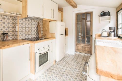 a kitchen with white appliances and a tile floor at Tilia in Damme