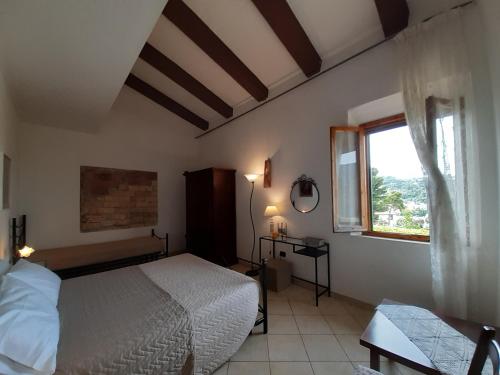 1 dormitorio con cama blanca y ventana en Agriturismo Il Gelso, en Pomaia