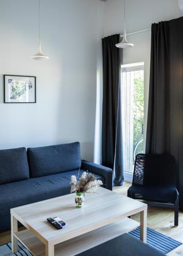 a living room with a blue couch and a coffee table at Alyvų Namai Nida in Nida