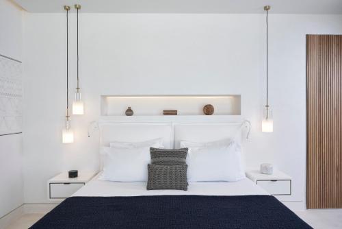 a bedroom with a large white bed with white pillows at The Island Concept Luxury Boutique Hotel Heated Pool in Agios Nikolaos