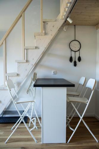 a room with a table and chairs and a staircase at Alyvų Namai Nida in Nida