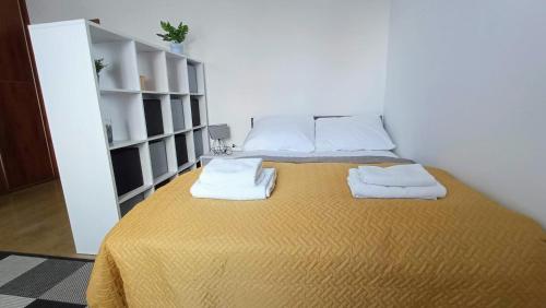 a bedroom with a bed with two towels on it at Apartament Orzysz "Żabi Staw" in Orzysz
