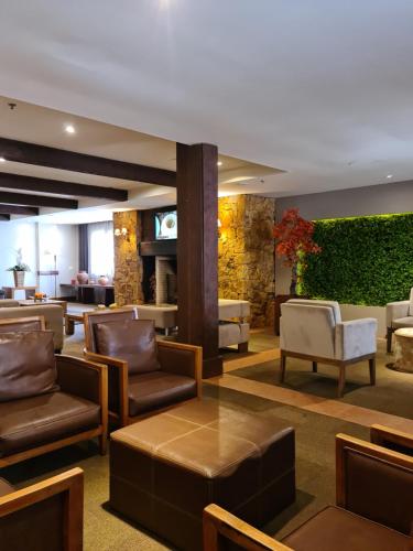 a lobby of a hotel with chairs and tables at Alpenhaus Gramado Flat Temporada in Gramado