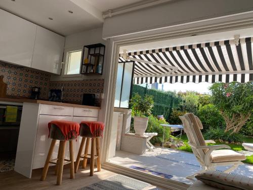 une cuisine avec deux tabourets et une cuisine avec un patio dans l'établissement Cannes Croisette &Palm beach,parking, à Cannes