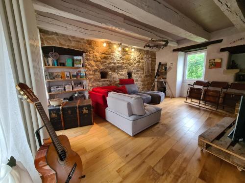 - un salon avec un canapé rouge et une guitare dans l'établissement Ma Maison Charme et déco atypique SophieAndCo, à Bozouls