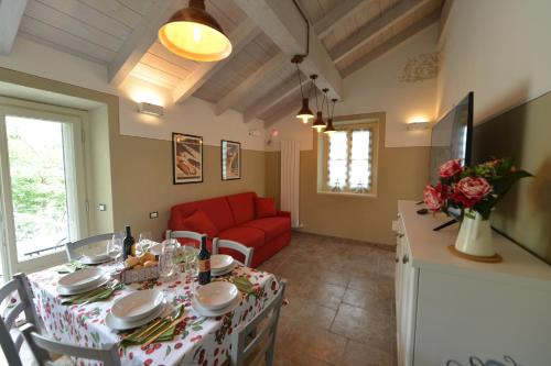 a living room with a table and a red couch at La Beppa - Casa Vacanza in Pontremoli