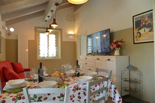 a dining room with a table and chairs and a television at La Beppa - Casa Vacanza in Pontremoli