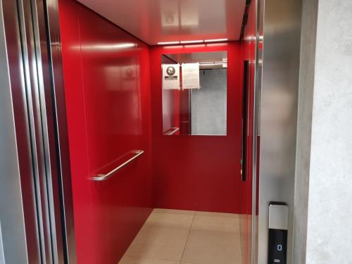 czerwona winda z czerwonymi drzwiami w budynku w obiekcie Apartament Kraków Arena No 76 w Krakowie