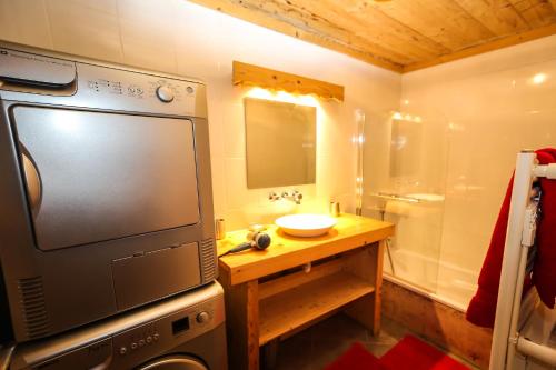 a bathroom with a television and a sink and a tub at Chalet Le Peak in Valloire