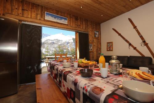 - une table avec de la nourriture et une vue sur la montagne dans l'établissement Chalet Le Peak, à Valloire