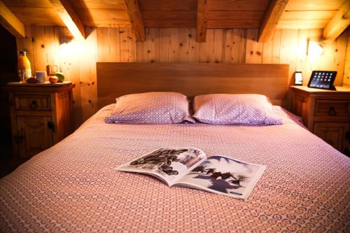 Un dormitorio con una cama con un libro. en Chalet Le Peak, en Valloire