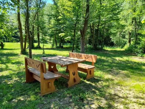 a picnic table and two benches in a park at Mała Gorczańska Chatka in Ochotnica Dolna