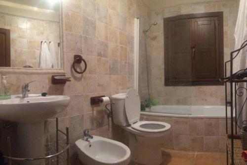 a bathroom with a toilet and a sink and a tub at Vivienda vacacional Los Nogales in Llanes