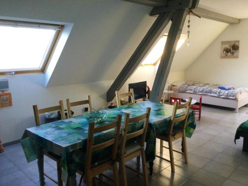 - une salle à manger avec une table, des chaises et un lit dans l'établissement Appartement charmant à Lohr + 60 m² + terrasse et jardin, à Lohr