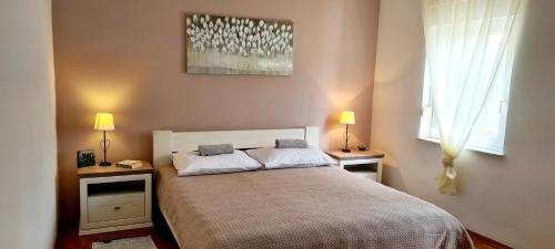 une chambre avec un lit avec deux tables de nuit et deux lampes dans l'établissement Apartment Garden & Sea, à Volosko
