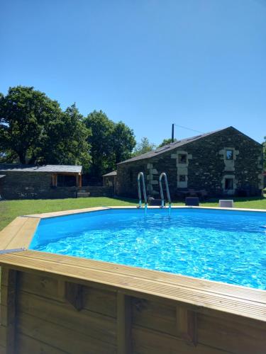 a large swimming pool with blue water in a yard at Albergue o Xistral in Abadín