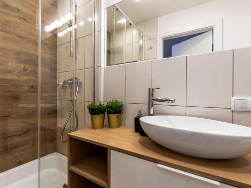 y baño con lavabo blanco y ducha. en VacationClub – Dubois 16C Apartament 11 en Kołobrzeg