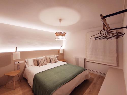 1 dormitorio con cama y lámpara de araña en FLOR DE LIS, en Sant Hilari Sacalm