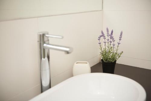 a bathroom with a white toilet and purple flowers at Apartments Gea Trogir in Trogir