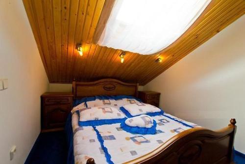 a bedroom with a bed with a wooden ceiling at Morshynska Vezha Hotel in Morshin