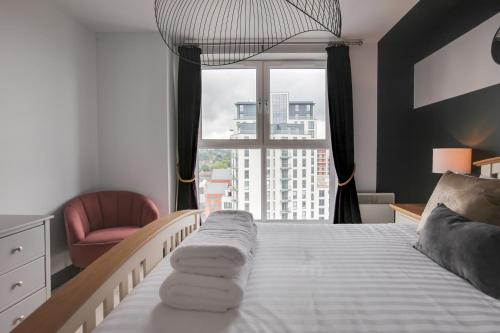 イプスウィッチにあるThe Marina Penthouseのベッドと椅子と窓のある寝室