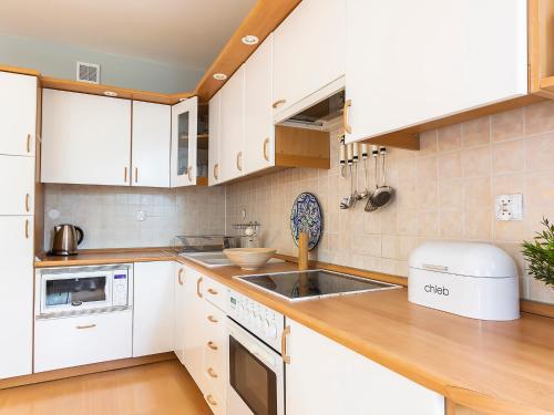 a kitchen with white cabinets and a sink at VacationClub – Campingowa 2A Apartament 11 in Międzyzdroje