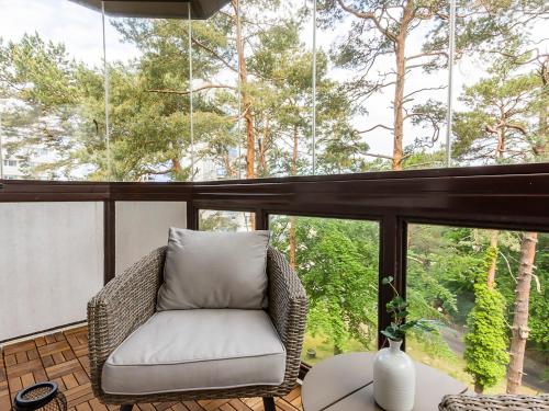a wicker chair sitting on a porch with a large window at VacationClub – Campingowa 2A Apartament 11 in Międzyzdroje