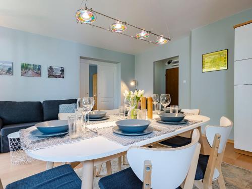 a dining room with a white table and chairs at VacationClub – Campingowa 2A Apartament 11 in Międzyzdroje