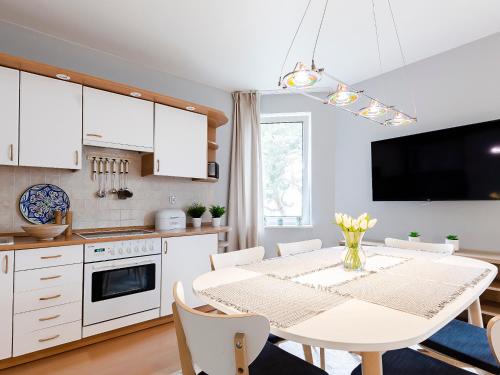 a kitchen and dining room with a white table and chairs at VacationClub – Campingowa 2A Apartament 11 in Międzyzdroje